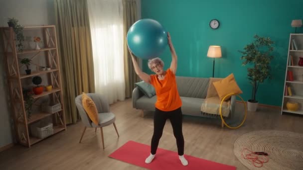 Äldre Kvinna Går För Sport Med Fitness Boll Vardagsrummet Gråhårig — Stockvideo