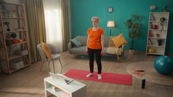 Eine Ältere Frau Turnt Mit Hanteln Vor Einem Laptop Wohnzimmer — Stockvideo