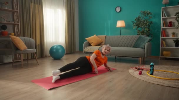 Een Oudere Vrouw Ligt Een Sportmat Vloer Woonkamer Doet Aan — Stockvideo