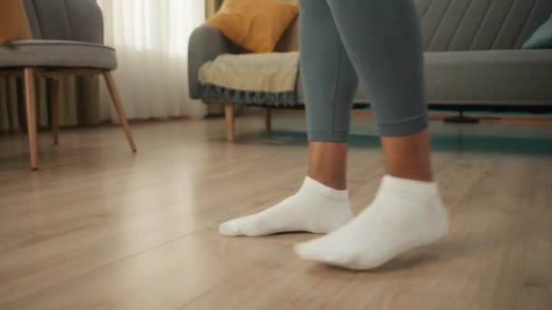 アフリカ系アメリカ人女性は自宅でワークアウトの準備をしている 白い靴下の女性の足を閉じます 女性がリビングの床にスポーツマットを敷いている スローモーション — ストック動画