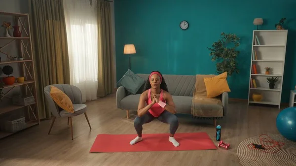 非洲裔美国妇女在客厅进行体育锻炼时做仰卧起坐 女人加强大腿 脚类和小腿肌肉的肌肉 — 图库照片