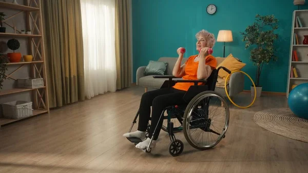 Tekerlekli Sandalyedeki Yaşlı Kadın Oturma Odasında Halterlerle Egzersiz Yapıyor Yaşlı — Stok fotoğraf