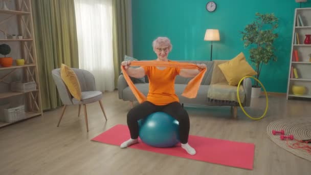 Starší Žena Sedí Fitballu Trénuje Sportovní Elastickou Páskou Obýváku Žena — Stock video