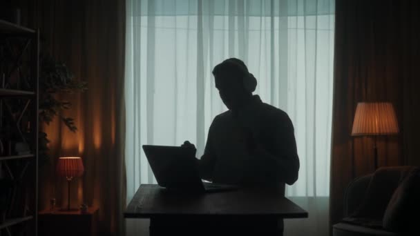 Silhouette Sombre Homme Casque Sans Fil Une Table Devant Ordinateur — Video