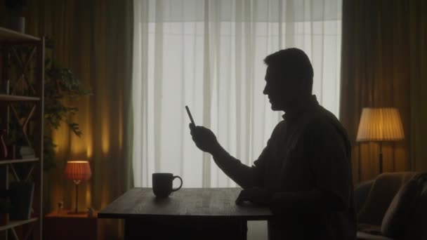 Egy Férfi Telefonon Beszél Egy Videóhíváson Miközben Egy Asztalnál Áll — Stock videók