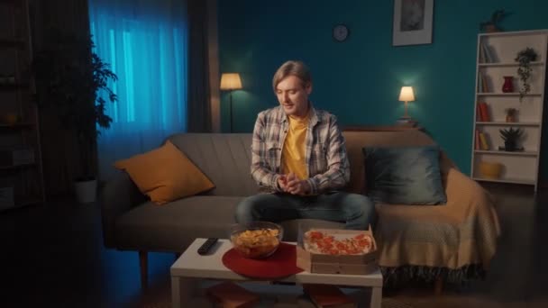 Mężczyzna Przygotowuje Się Oglądania Filmu Przynosi Talerz Chipsów Pudełka Pizzy — Wideo stockowe