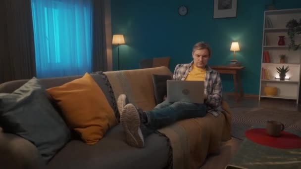 Jovem Está Deitado Sofá Sala Estar Com Laptop Colo Homem — Vídeo de Stock