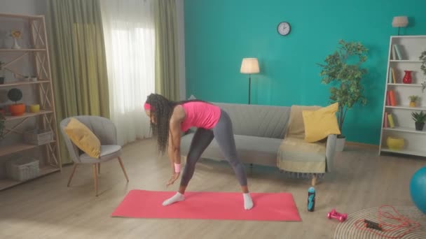 一个女人在客厅里锻炼前正在热身 一个身材苗条的非洲裔美国女子做侧弯和前倾 家庭健身的概念 慢动作Hdr Bt2020 Hlg Material — 图库视频影像