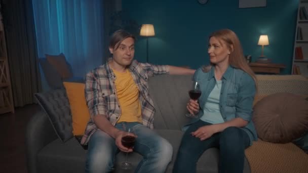Jovem Casal Senta Sofá Noite Conversando Bebendo Vinho Homem Compartilha — Vídeo de Stock