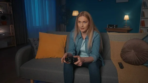 Bir Kadın Akşamları Evdeki Kanepede Otururken Oyun Kontrolörüyle Konsolosluk Oyunu — Stok fotoğraf