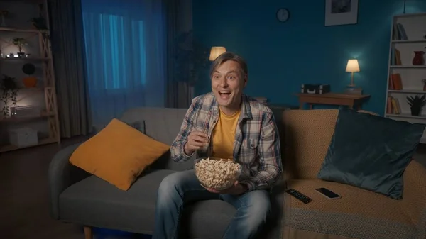 Wieczorem Mężczyzna Siedzi Kanapie Popcorn Ogląda Telewizję Mężczyzna Ogląda Komedię — Zdjęcie stockowe