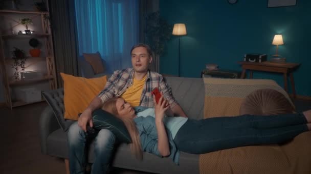 Manželé Večer Odpočívají Obýváku Muž Sedí Gauči Dívá Televizi Přepíná — Stock video