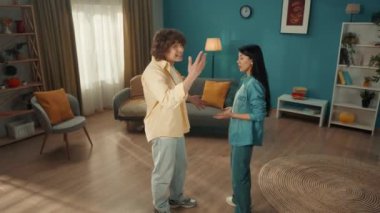 Aile kavgası. Oturma odasında kavga eden, bağıran ve birbirlerini suçlayan genç bir çift. Aile sorunları, çatışma, kötü ilişkiler