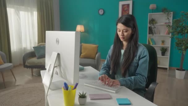 若いアジアの女性がコンピュータに座っている間にスマートフォンで話しています 女性は会話を終了し キーボードを入力し メッセージを書き チャットし フリーランスになります Hdr Bt2020 Hlg — ストック動画