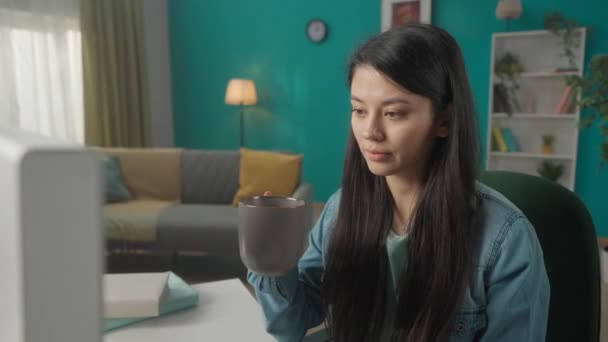 Kobieta Siedzi Przy Komputerze Pije Poranną Kawę Herbatę Azjatka Pisząca — Wideo stockowe