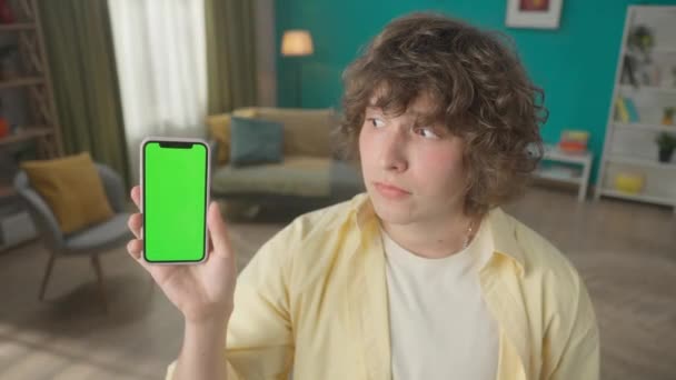 Молодой Человек Показывает Смартфон Зеленым Экраном Кивает Головой Знак Согласия — стоковое видео