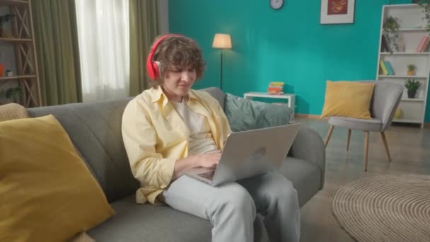 Jeune Homme Est Assis Sur Canapé Portant Des Écouteurs Sans — Video