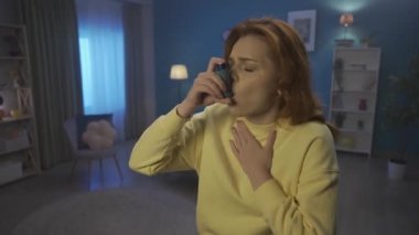 A woman uses an asthma inhaler during a coughing fit close up. A woman using an inhaler begins to breathe normally. Home medicine concept. HDR BT2020 HLG Material