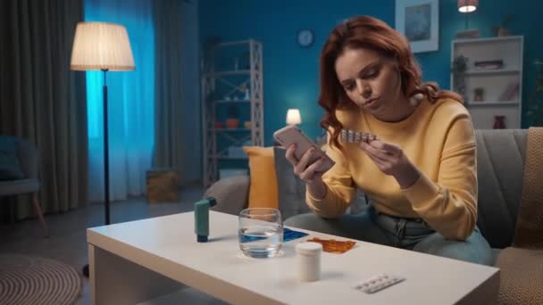 Kobieta Używająca Smartfona Bada Instrukcję Zażywania Tabletek Kobieta Siedzi Kanapie — Wideo stockowe