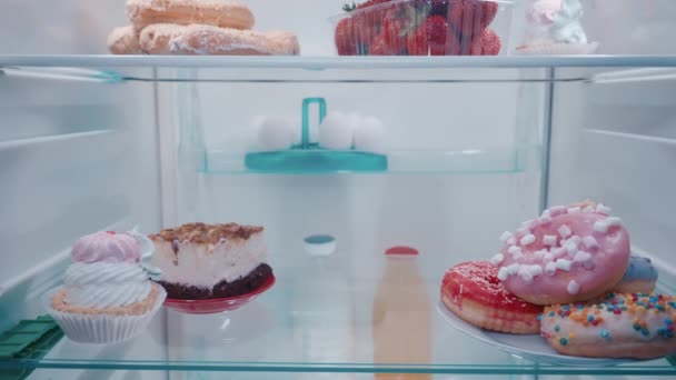 Нездоровая Пища Полках Холодильника Торты Эклеры Пончики Дверь Холодильника Открывается — стоковое видео