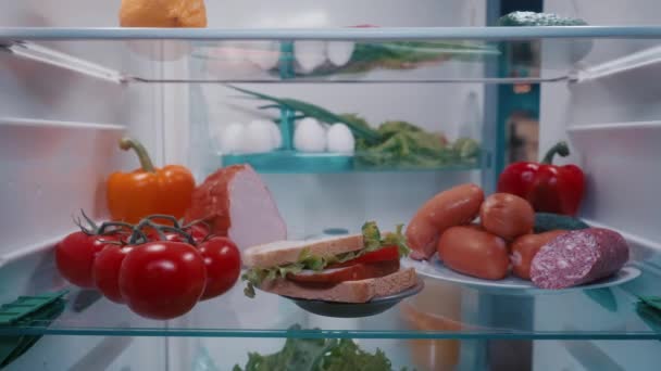 Холодильник Овощами Колбасой Сэндвичем Полках Вид Изнутри Дверь Открывается Мужчина — стоковое видео