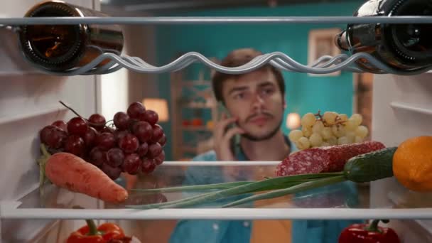 Man Phone His Ear Opens Refrigerator Door Man Inspects Food — Stock Video