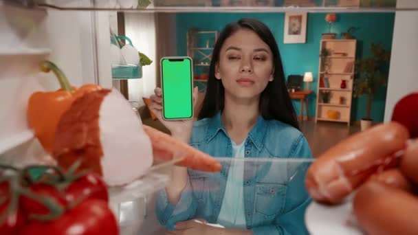 Asian Woman Showing Smartphone Green Screen Woman Stands Open Refrigerator — Stock Video