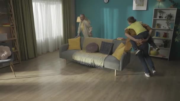 Funny Family Scene Dad Piggybacking His Son Running Couch Trying — Stock Video
