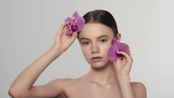 Portret Atrakcyjnej Brunetki Świeżą Skórą Zbliżenie Kobietę Dotykającą Twarzy Kwiatami — Wideo stockowe