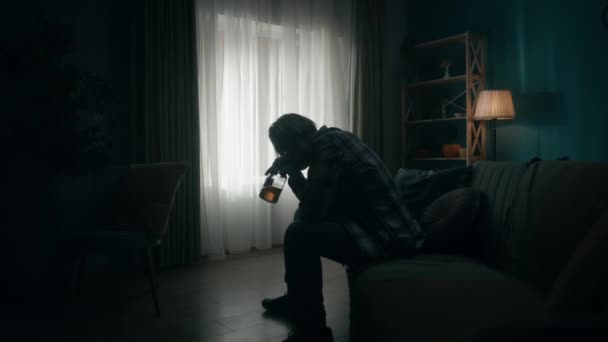 Зруйнований Молодий Чоловік Сидить Кімнаті Темряві Пляшкою Алкоголю Горла Алкоголізм — стокове відео