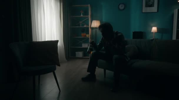 Ένας Συντετριμμένος Νεαρός Κάθεται Ένα Δωμάτιο Στο Σκοτάδι Ένα Μπουκάλι — Αρχείο Βίντεο
