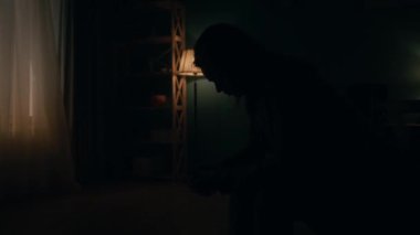 Mahvolmuş yalnız bir kadın, odanın ortasında, zifiri karanlıkta başı eğilmiş bir sandalyeye oturur. Gece gündüzü takip eder, bir kadın başını kaldırır ve pencereden ışığa bakar.