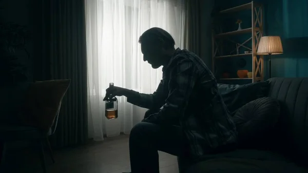 Yıkılmış Bir Adam Elinde Bir Şişe Alkolle Karanlık Bir Odada — Stok fotoğraf
