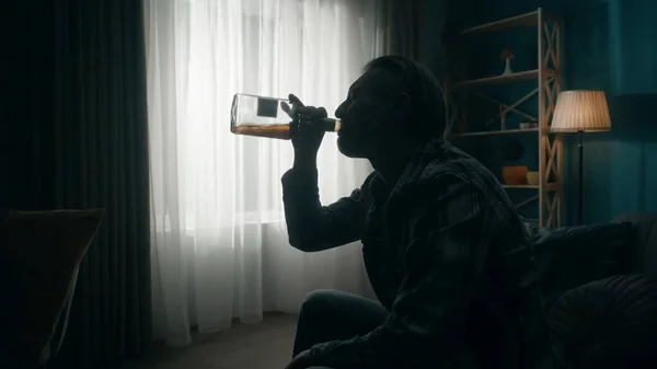 Widok Boku Ciemnej Sylwetki Człowieka Opróżniającego Butelkę Alkoholu Mężczyzna Siedzi — Zdjęcie stockowe