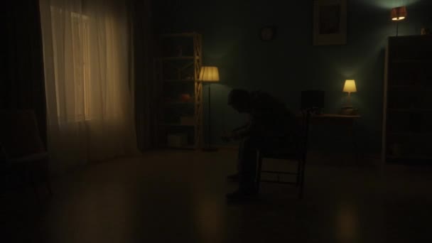 Опустошенный Одинокий Человек Сидит Головой Склоненной Стуле Посреди Комнаты Кромешной — стоковое видео