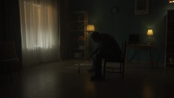 Ein Mann Sitzt Der Dunkelheit Auf Einem Stuhl Raum Ein — Stockvideo