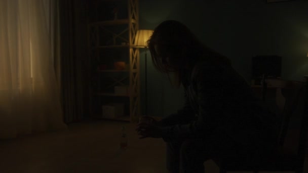 Женщина Сидит Стуле Темноте Стаканом Крупным Планом Бутылка Алкоголя Полу — стоковое видео