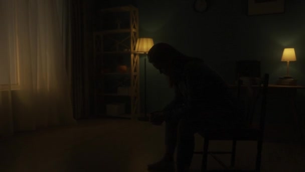 Uma Mulher Senta Com Cabeça Curvada Uma Cadeira Sala Escuridão — Vídeo de Stock