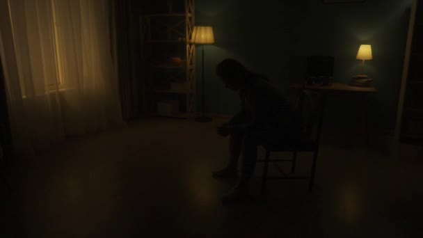 女性は暗闇の中で部屋の椅子に頭を下げて座っている 夜が明けると 女性が頭を上げて窓から光を見る 時間のトランシス ホープコンセプト — ストック動画