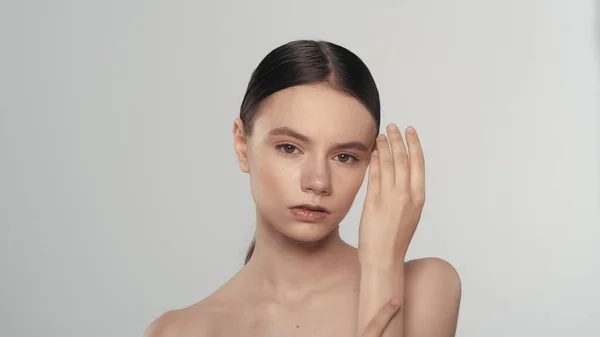 迷人的高加索黑发模特的肖像 一个有着自然妆容的女人的近照 看着相机 摸着她纯洁的手的皮肤 美容美发广告概念 — 图库照片