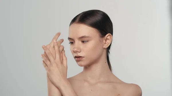 魅力的な白人モデルの肖像画 カメラから離れた若い女性のショットを閉じて 彼女の手に保湿剤クリームを塗ります ハンドケア広告コンセプト — ストック写真