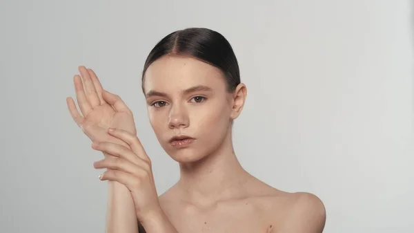 美しいブルネット女性モデルの肖像画 カメラを見ている女性のショットを閉じて 手の滑らかな肌に触れました ビューティーハンドケア広告コンセプト — ストック写真