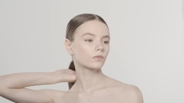 Kafkasyalı güzel esmer modelin portresi. Stüdyo, parlak saçlarına dokunan bir kadının yakın çekimi. Kameradan uzağa bakıyor. Güzellik saç bakım reklamı konsepti. HDR BT2020 HLG Malzemesi.