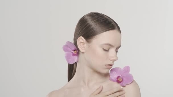 코카서스 모델의 초상화 어깨에 꽃이있는 여자의 닫습니다 그녀는 칼라본 부위에 — 비디오