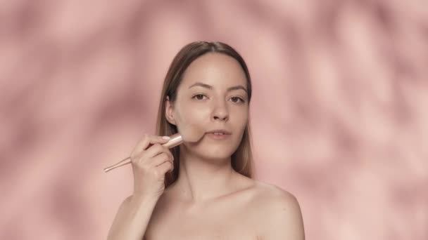 Seminude Vrouw Gebruikt Een Make Borstel Studio Een Roze Achtergrond — Stockvideo