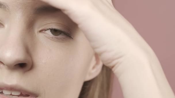 Vágott Kép Egy Arcáról Stúdióban Rózsaszín Háttérrel Közelről Egy Végigsimítja — Stock videók