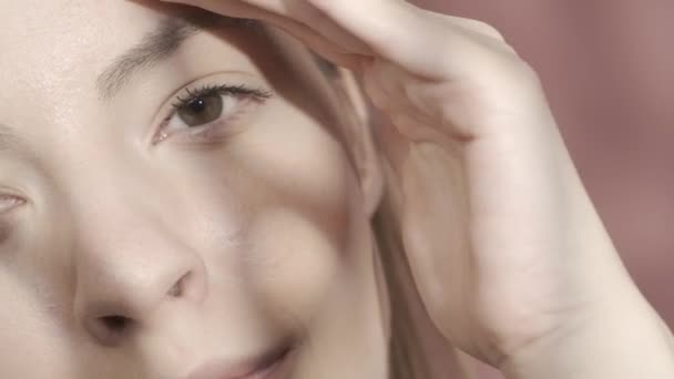 Vágott Kép Egy Arcáról Stúdióban Rózsaszín Háttérrel Közelről Végigsimítja Szemöldökét — Stock videók