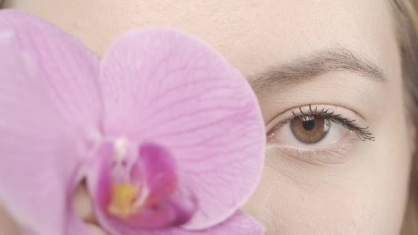 Egy Fiatal Gyönyörű Szemei Közelednek Egy Eltakarja Szemét Egy Orchideavirággal — Stock videók