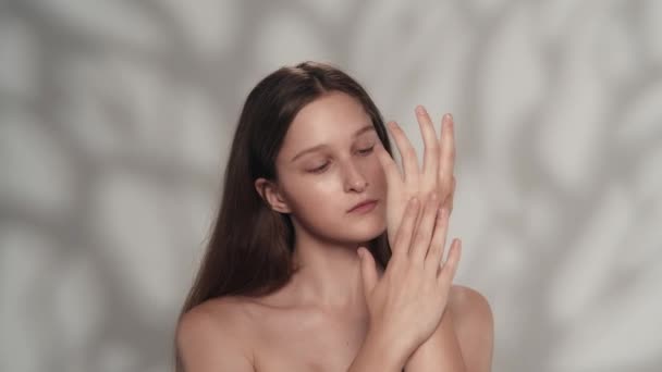 매력적인 코카서스 모델의 초상화 카메라를보고 그녀의 보습제 크림을 적용하는 소녀의 — 비디오