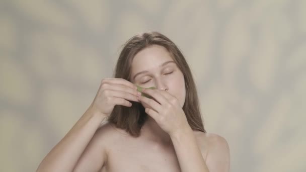 一个漂亮的黑发女模特的画像 近照一个女孩拿着一个绿色眼罩并在她的眼睛下贴了一个绿色眼罩 日常美容治疗 眼部护肤广告的概念 Hdr Bt2020 — 图库视频影像